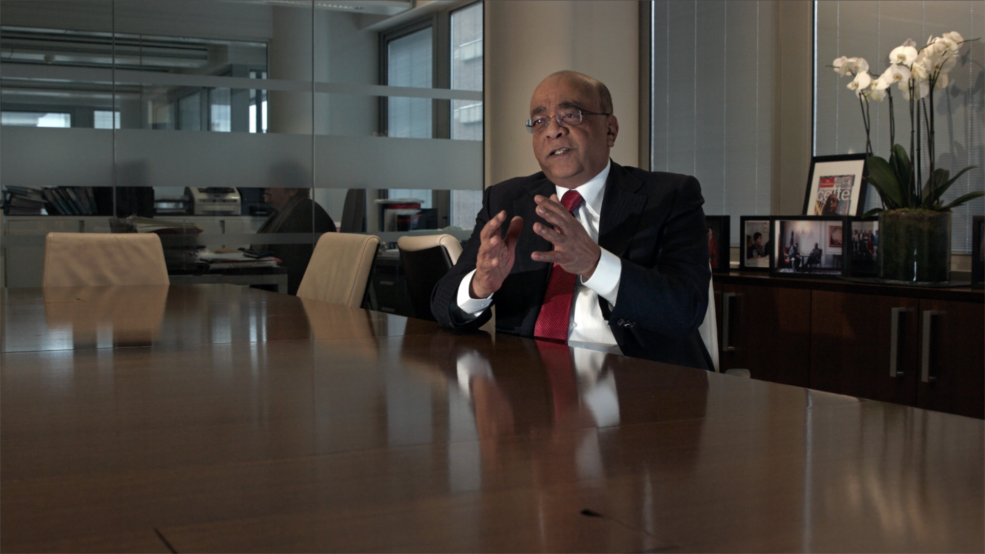 Disparity Film Still, Dr Mo Ibrahim sitting at desk