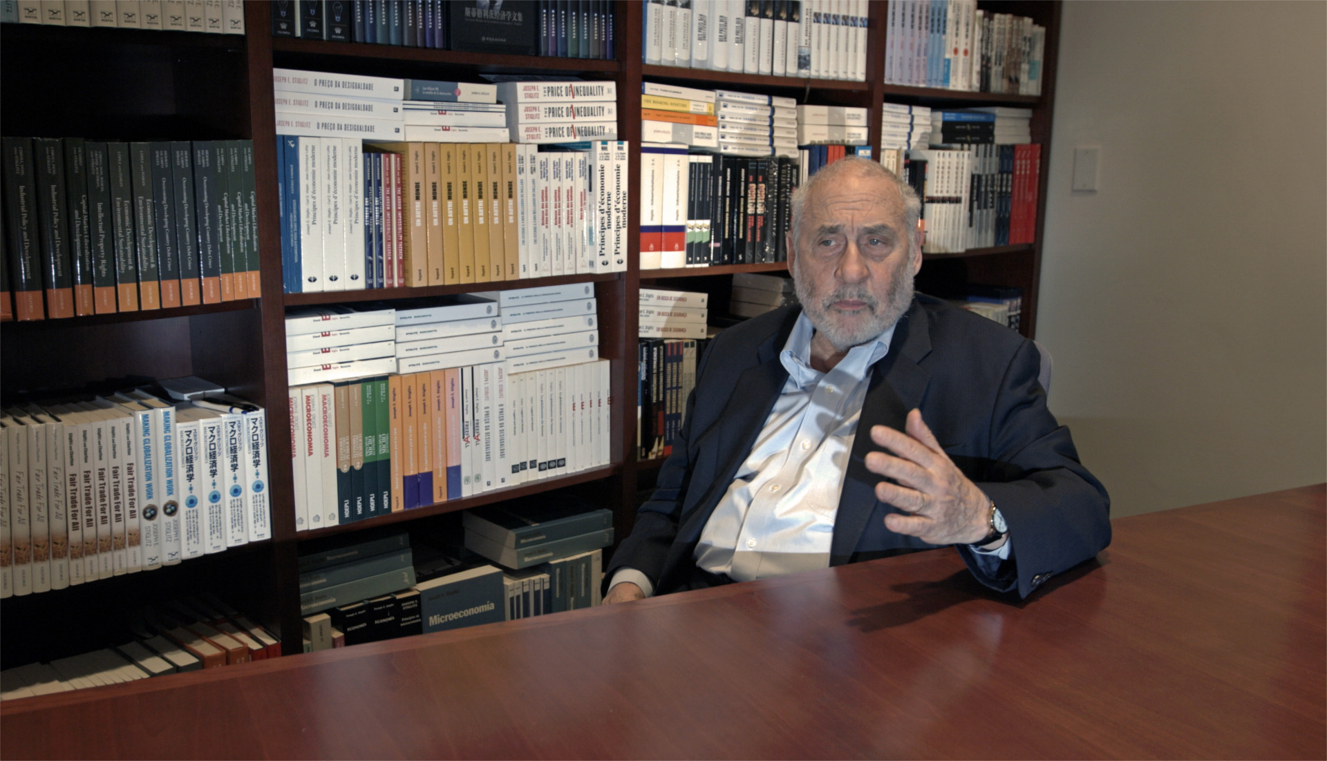 Disparity Film Still, Joseph Stiglitz sitting in front of bookshelf